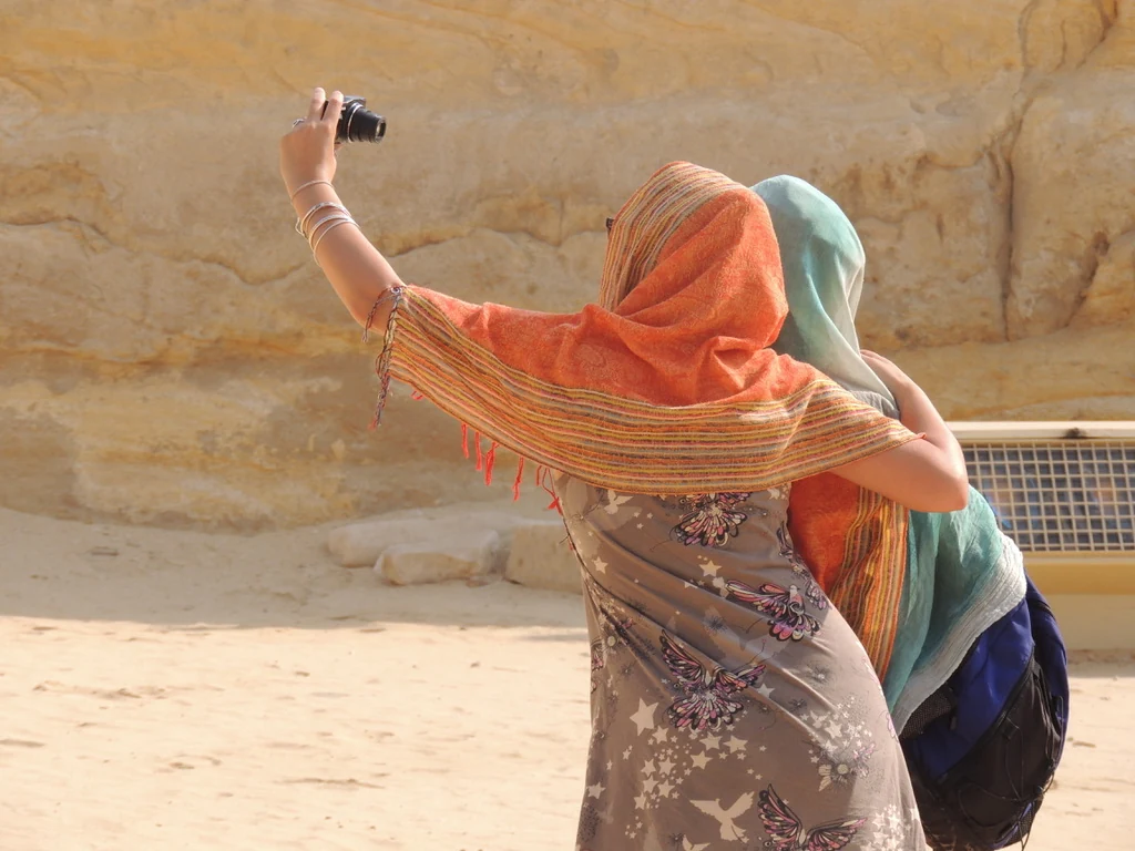 Two women sharing a moment at the paws of the Great Sphinx at Giza, Egypt